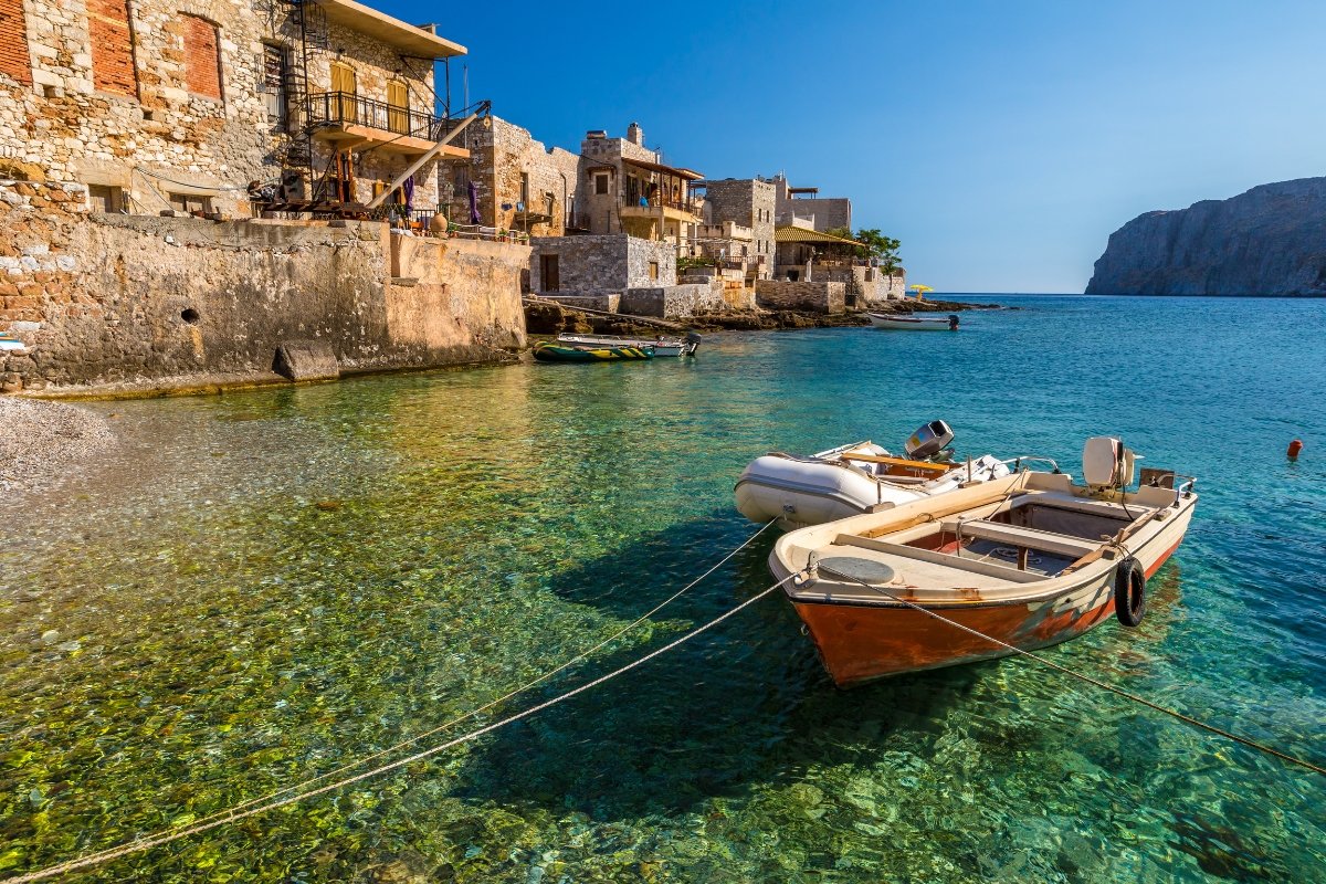 A beautiful daylight scene with a small boat anchored on a greek beach