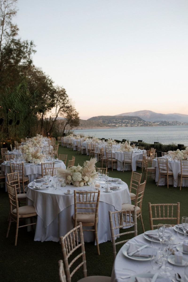 Outdoor wedding reception setup on the Athens Riviera with a panoramic sea view