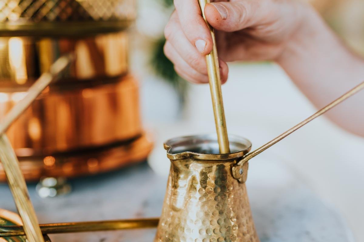 Traditional Greek coffee being stirred in a copper briki — a daily Mediterranean ritual full of aroma and history
