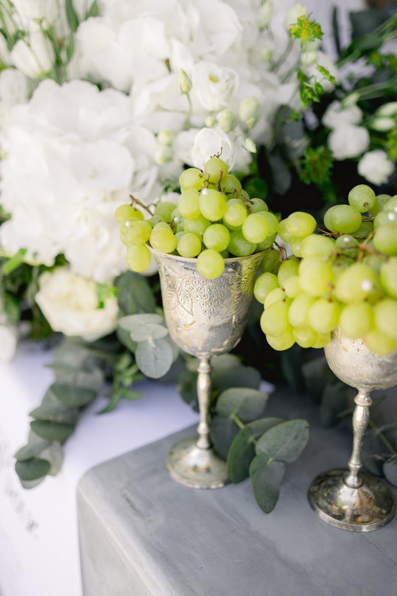 Close-up of white and green floral wedding centerpieces at a Greek wedding reception