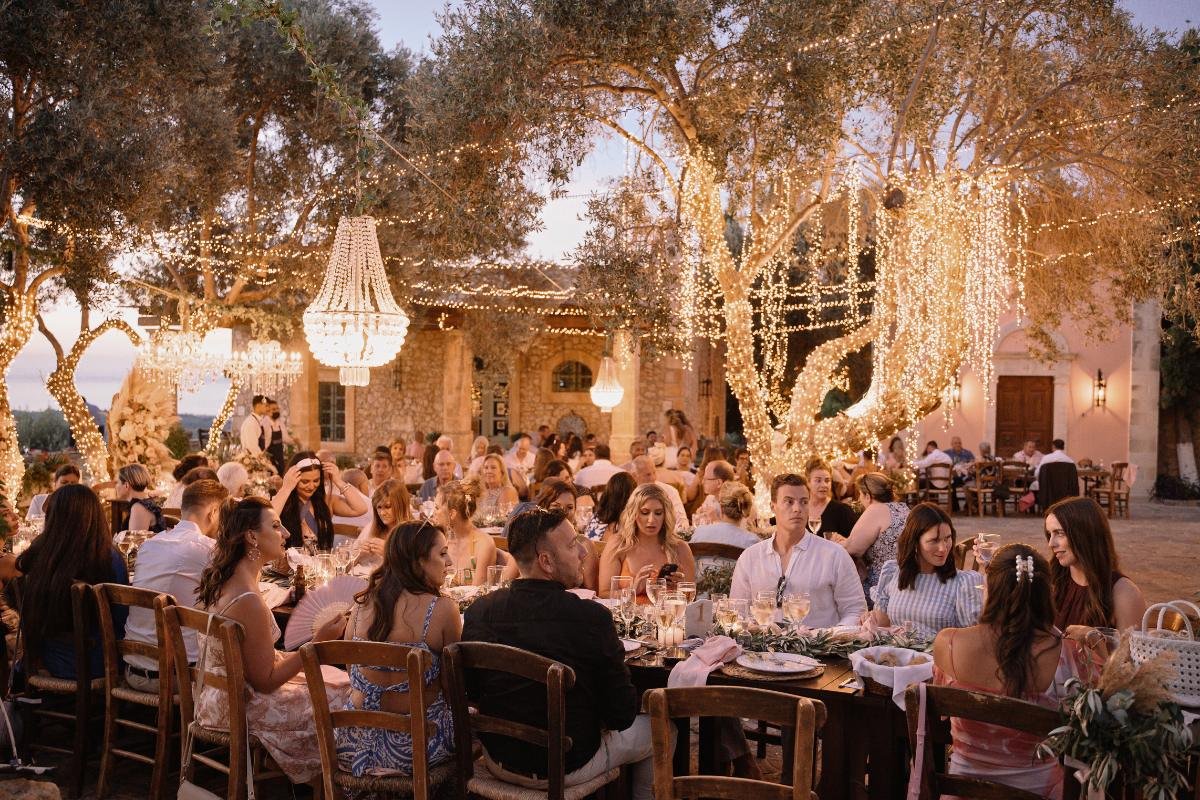Intimate vineyard wedding dinner under olive trees in Crete, with faily lights