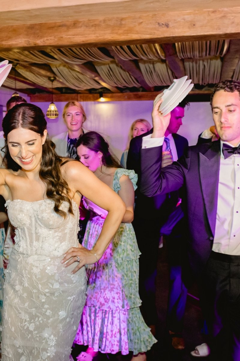 Bride and groom dancing with guests during a traditional Greek wedding celebration