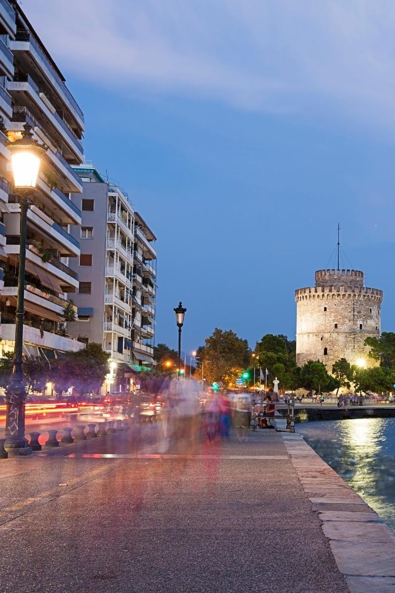 A motion-blurred evening shot of the Thessaloniki waterfront during golden hour, capturing the energy of the city's slow living.