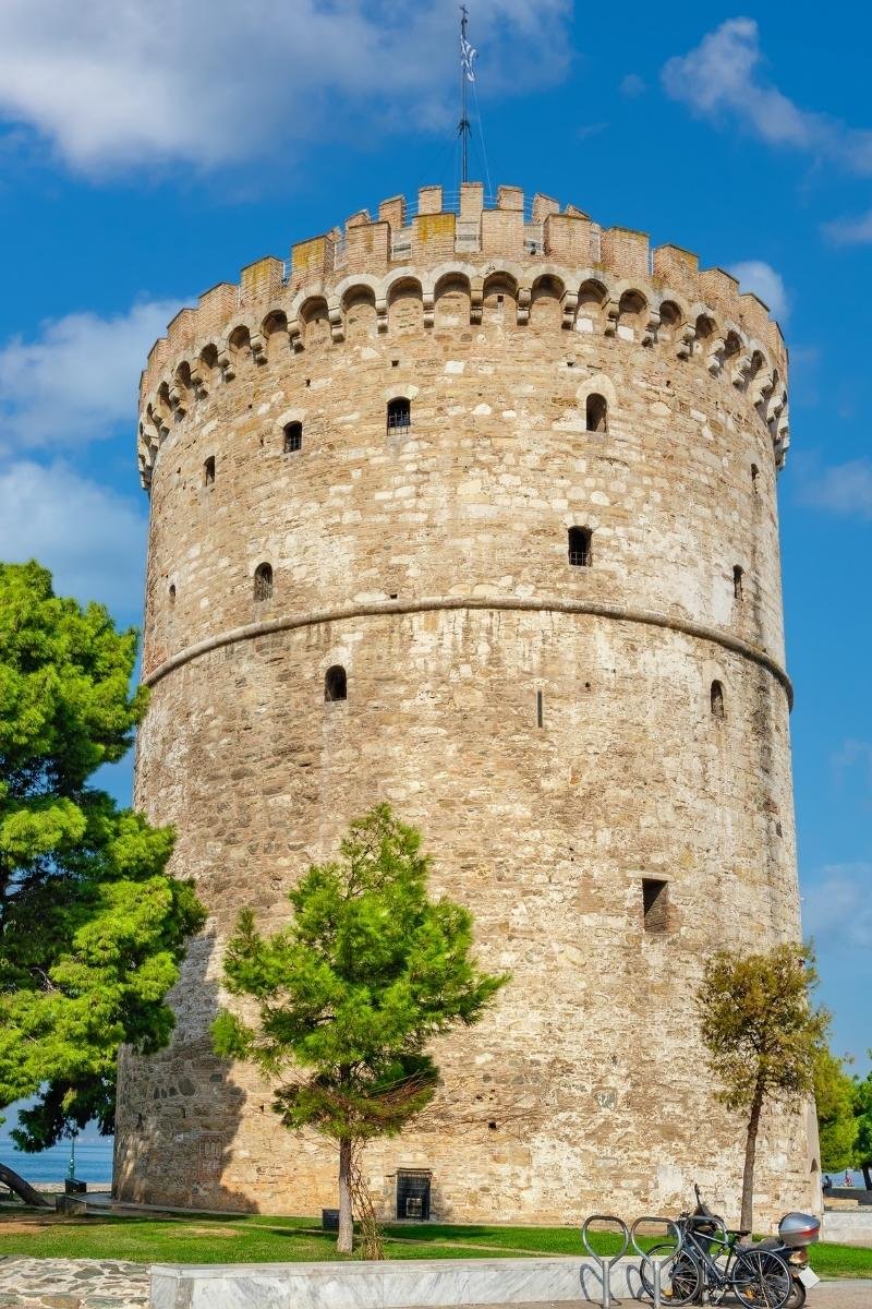 The historic White Tower of Thessaloniki against a blue sky, representing the city's Byzantine and Ottoman heritage.
